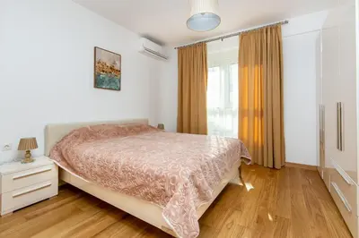 a bedroom with a bed and a window at Apartments LM RESIDENCE in Rafailovici