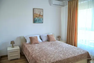 a bedroom with a bed and a window at Apartments LM RESIDENCE in Rafailovici
