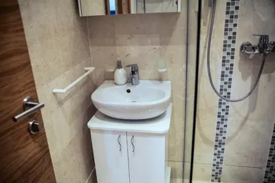 a bathroom with a sink and a shower at Apartments LM RESIDENCE in Rafailovici