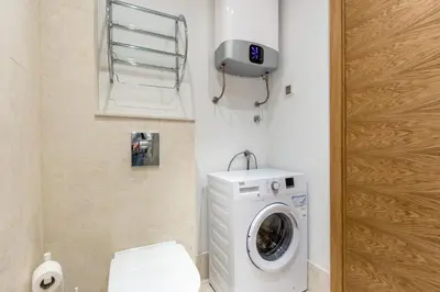 a bathroom with a washing machine and a toilet at Apartments LM RESIDENCE in Rafailovici