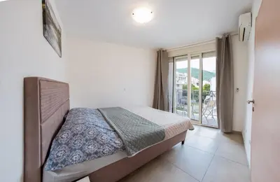 a bedroom with a bed and a balcony at Square Inn in Budva