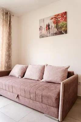 a couch in a living room with a painting on the wall at Square Inn in Budva