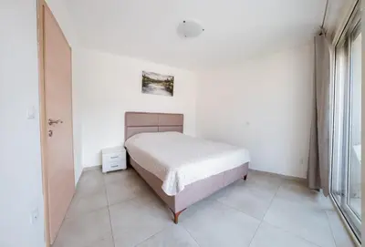 a bedroom with a bed in a white room at Square Inn in Budva