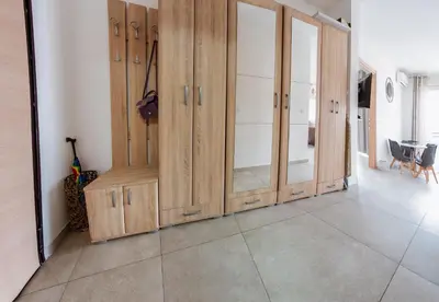 a living room with wooden cabinets and a tiled floor at Square Inn in Budva