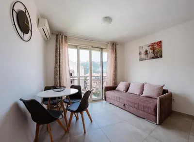 a living room with a couch and a table and chairs at Square Inn in Budva