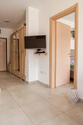a room with a door with a television on a wall at Square Inn in Budva