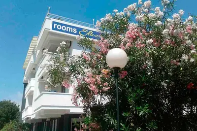 a building with a street light in front of a tree at villa elkom-appartamento giallo 1 in Ulcinj
