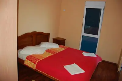 a bedroom with a bed with a red blanket and a window at villa elkom-appartamento giallo 1 in Ulcinj