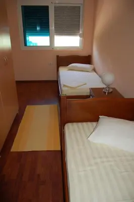 a small room with three beds and a window at villa elkom-appartamento giallo 1 in Ulcinj