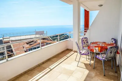 a balcony with a table and chairs and the ocean at Apartments Monte in Ulcinj