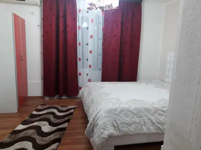 a bedroom with red curtains and a bed and a rug at Apartments Monte in Ulcinj