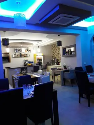 a restaurant with tables and chairs and blue lighting at Apartments Monte in Ulcinj