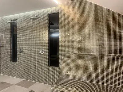 a bathroom with a shower and a mirror at Hotel Sato Conference & SPA Resort in Sutomore