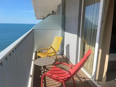 two chairs and a table on a balcony with the ocean at Hotel Sato Conference & SPA Resort in Sutomore