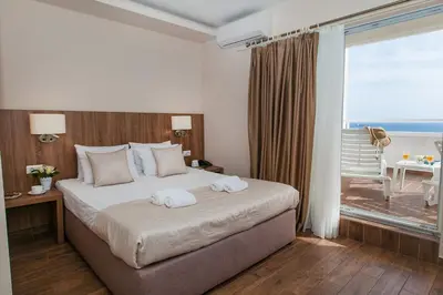 a hotel room with a bed with towels on it at Hotel Sato Conference & SPA Resort in Sutomore