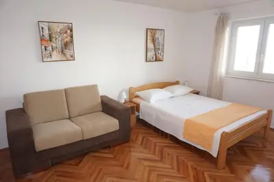 a bedroom with a bed and a couch at Apartments Krš Medinski in Petrovac na Moru