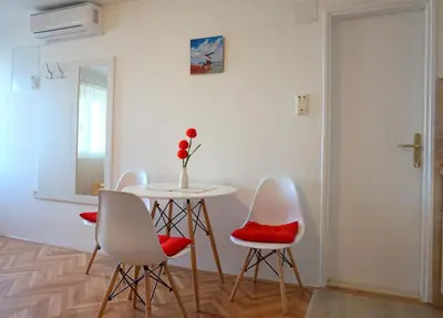 a room with a table and chairs and a vase of flowers at Apartments Krš Medinski in Petrovac na Moru