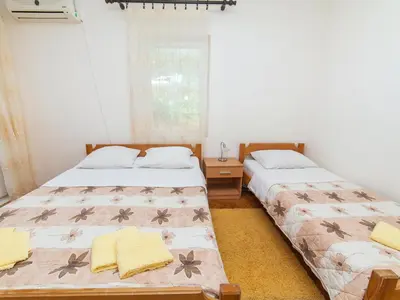 a bedroom with two beds and a window at Apartments Krš Medinski in Petrovac na Moru
