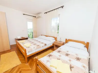 a bedroom with two beds and a window at Apartments Krš Medinski in Petrovac na Moru