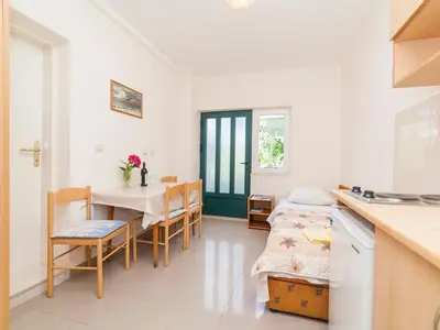 a kitchen and dining room with a table and chairs at Apartments Krš Medinski in Petrovac na Moru