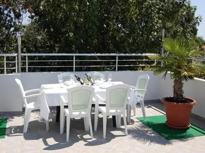 a white table with white chairs and a potted plant at Villa Elkom, App. 8 in Ulcinj