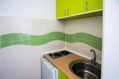 a small kitchen with a sink and green and white tiles at Villa Elkom, App. 8 in Ulcinj