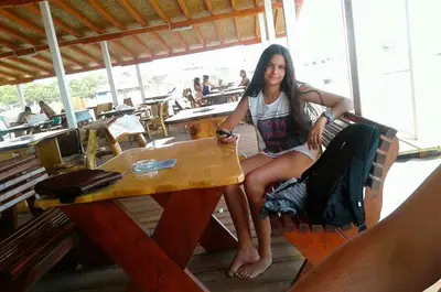a woman is sitting at a table at a table at Villa Elkom, App. 8 in Ulcinj