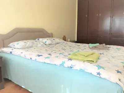 a bed with a blue comforter with a towel on it at SunFlat Podgorica - Novakovic Residence in Podgorica