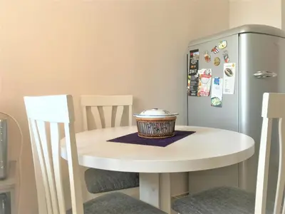 a small white table with a refrigerator in a kitchen at SunFlat Podgorica - Novakovic Residence in Podgorica
