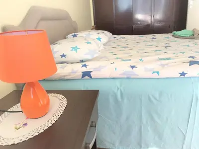 an orange lamp sitting on a table next to a bed at SunFlat Podgorica - Novakovic Residence in Podgorica