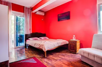 a red bedroom with a bed and a couch at Villa Elkom, App.3 in Ulcinj