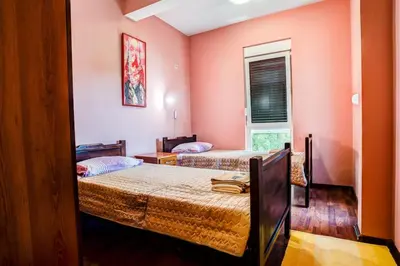 two beds in a room with pink walls at Villa Elkom, App.4 in Ulcinj