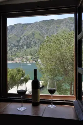 a bottle of wine and two glasses on a window at Apartments Vujošević in Kotor