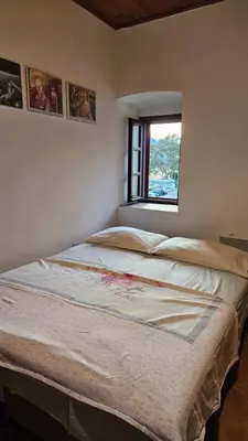 a large bed in a room with a window at Apartments Vujošević in Kotor