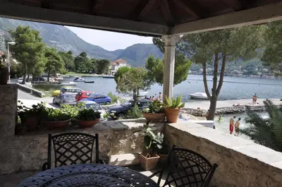 a balcony with two chairs and a view of a lake at Apartments Vujošević in Kotor