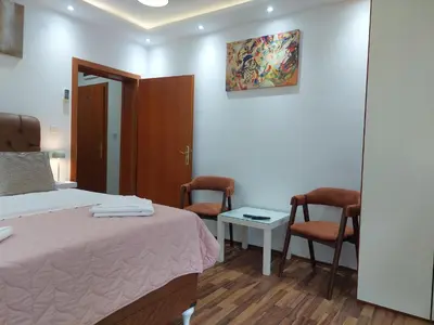 a bedroom with a bed and two chairs and a table at Apartments Nancy in Kotor