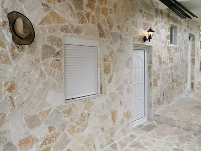 a stone wall with a window and a door at STUDIO Carpe Diem in Utjeha