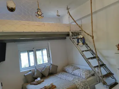 a room with a bunk bed and a ladder at STUDIO Carpe Diem in Utjeha