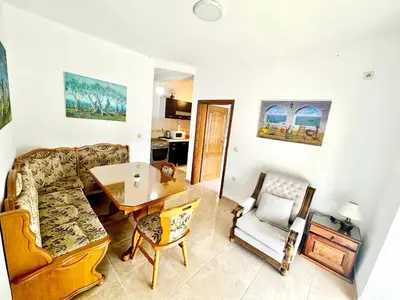 a living room with a couch and a table and chairs at Sea View Apartment Ulcinj 80 m² in Ulcinj