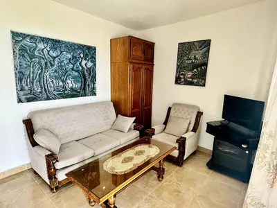 a living room with a couch and a table and a piano at Sea View Apartment Ulcinj 80 m² in Ulcinj