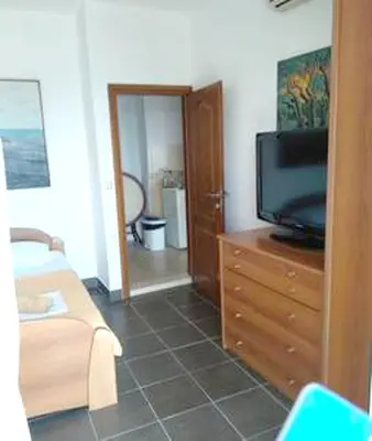 a living room with a tv on a wooden dresser at Comfortable Apartment in Ulcinj with Sea View and Garden in Ulcinj