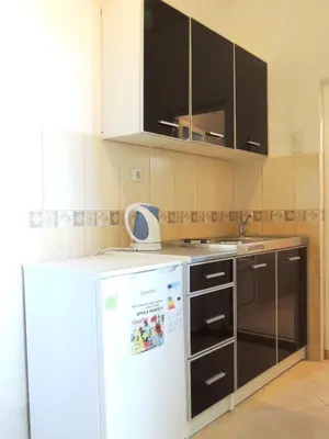 a kitchen with a white refrigerator and black cabinets at Comfortable Apartment in Ulcinj with Sea View and Garden in Ulcinj