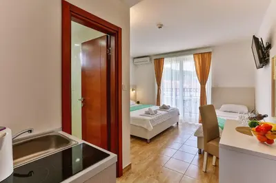 a room with a kitchen and a bedroom with a bed at Villa Skyprime in Budva
