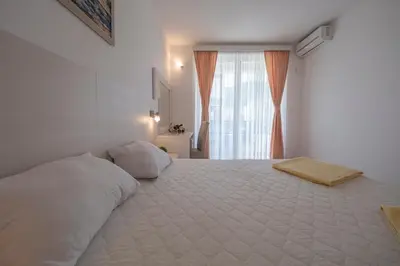 a bedroom with a large white bed with a window at Villa Skyprime in Budva