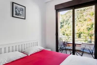 a bedroom with a red bed and a balcony at Apartment with bedroom Becici White in Becici