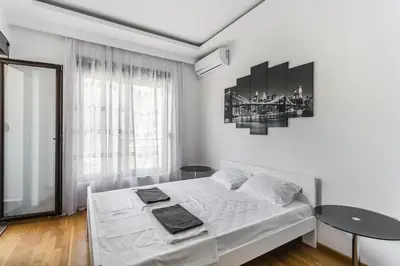 a white bedroom with a bed and a window at Apartment with bedroom Becici White in Becici