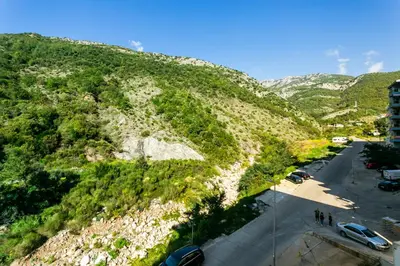 a mountain with cars parked in a parking lot at Apartment with bedroom Becici White in Becici