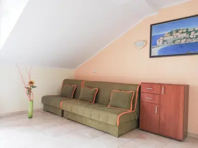 a couch in a living room with a painting on the wall at Apartment Azalea of Budva in Budva