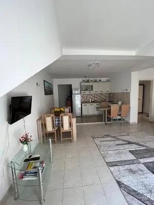 a living room with a glass table and a kitchen at Apartment Azalea of Budva in Budva