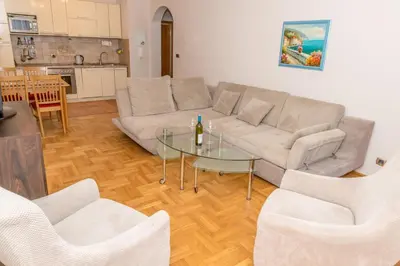 a living room with a couch and a glass table at Apartment Qservice Petrovac in Budva